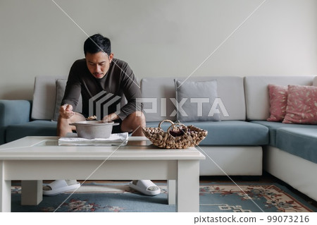 Lonely man having a meal alone in his home. 99073216