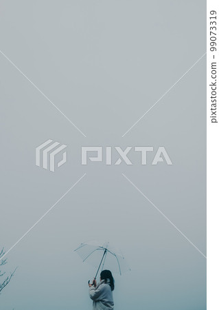 Photo of a woman holding an umbrella in the city background 99073319