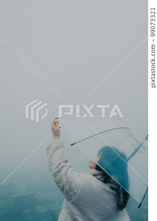 Photo of a woman holding an umbrella in the city background 99073321