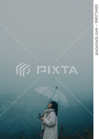 城市背景下撐著雨傘聽音樂的女人照片 城市背景下撐著雨傘聽音樂的女人照片 99073489