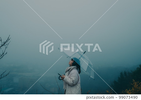 城市背景下撐著雨傘聽音樂的女人照片 城市背景下撐著雨傘聽音樂的女人照片 99073490