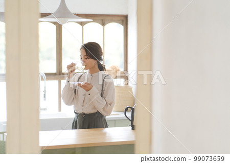 A woman drinking a hot drink 99073659
