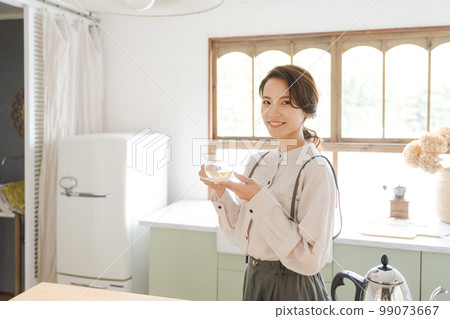 A woman drinking a hot drink 99073667