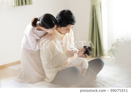 Family Dad giving milk with a baby bottle 99075851