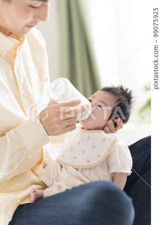 Family Dad giving milk with a baby bottle 99075925