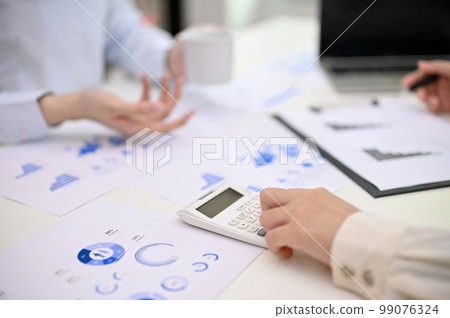 Cropped image of a female accountant using calculator, calculating and analyzing financial data Cropped image of a female accountant using calculator, calculating and analyzing financial data 99076324