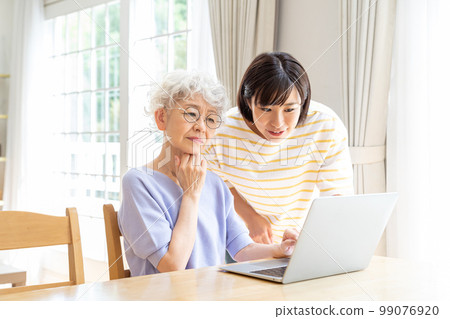 Senior woman learning computer in living room 99076920