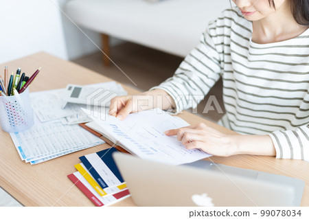 A woman checking her household budget for inflation 99078034