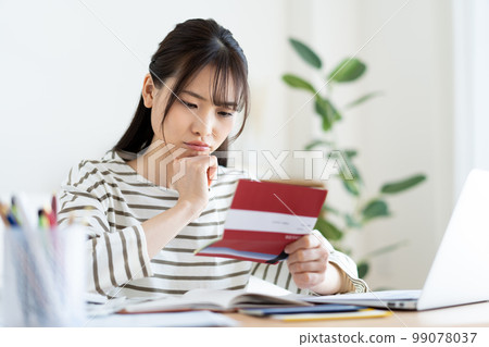 A woman who is worried about looking at her bankbook due to inflation A woman who is worried about looking at her bankbook due to inflation 99078037