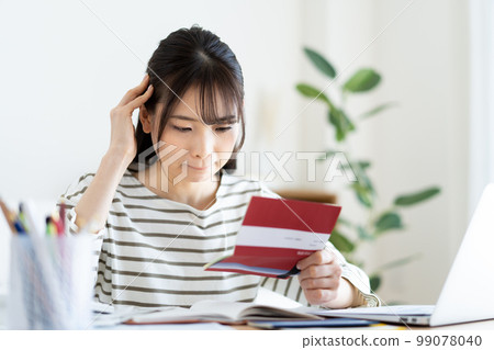 A woman who is worried about looking at her bankbook due to inflation A woman who is worried about looking at her bankbook due to inflation 99078040