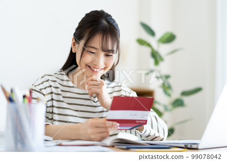A woman checking a bankbook with inflation A woman checking a bankbook with inflation 99078042