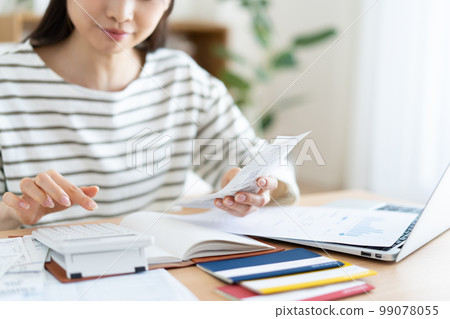 A woman checking her household budget for inflation 99078055