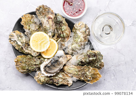 Fresh oysters with sauce and lemons 99078134
