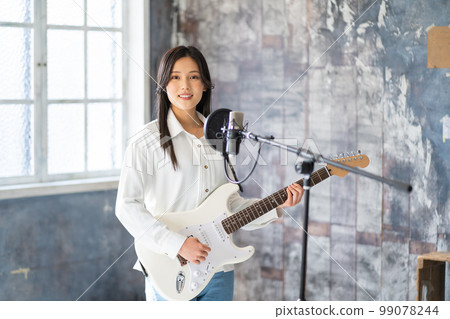 Young woman portrait (electric guitar, vocal) 99078244
