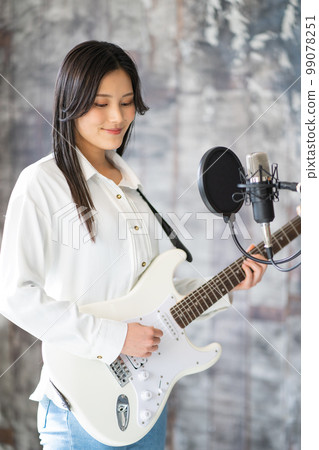Young woman portrait (electric guitar, vocal) 99078251