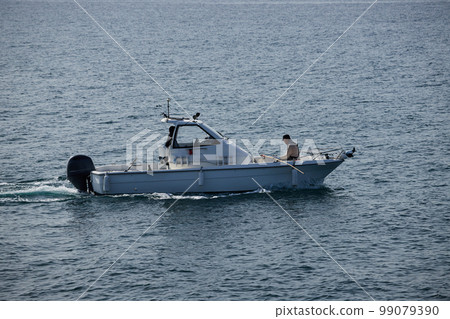 Fishing boat and senior man figure sailing on sea surface 99079390