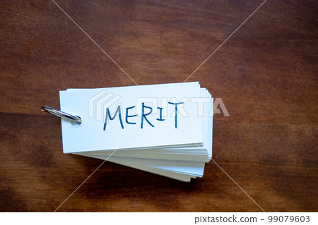 桌子上放了一張字卡,字母“MERIT” 桌子上放了一張字卡,字母“MERIT” 99079603