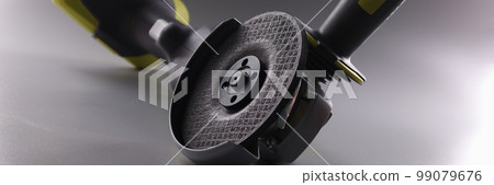 Professional angle grinder with disc on gray background Professional angle grinder with disc on gray background 99079676