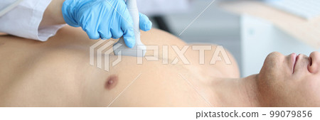 Doctor holding ultrasound machine on man chest in clinic 99079856