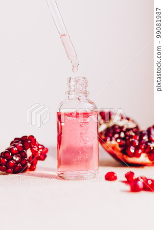 Pomegranate oil in a cosmetic bottle with a pipette. Natural cosmetics and face care Pomegranate oil in a cosmetic bottle with a pipette. Natural cosmetics and face care 99081987