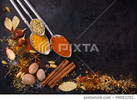 Different spices and herbs on a black background Different spices and herbs on a black background 99082201
