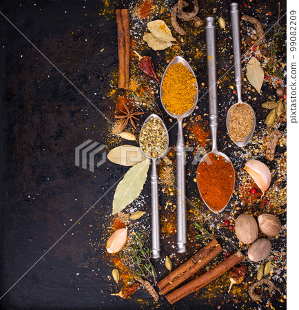Different spices and herbs on a black background 99082209