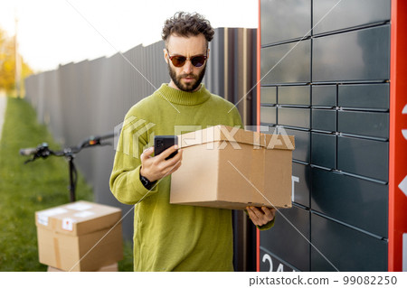 Man receiving parcel from automatic post box 99082250