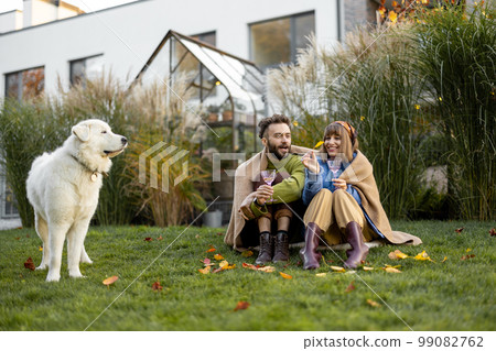 Young couple with dog at backyard Young couple with dog at backyard 99082762