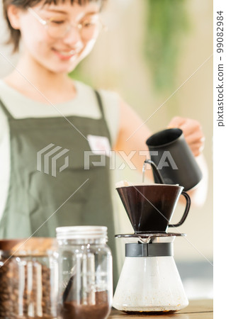 年輕女子在咖啡壺裡沖泡咖啡 99082984