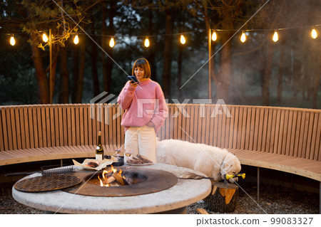 Woman spends leisure time with her dog at lounge outdoor area 99083327