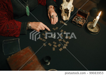 Old mature witch giving prediction using spiritual attributes closeup top view 99083953