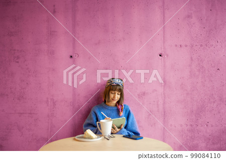 Woman works on touchpad at coffee shop Woman works on touchpad at coffee shop 99084110
