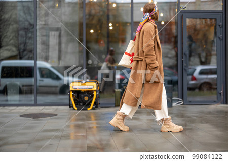 Woman walks on a street with gasoline generator Woman walks on a street with gasoline generator 99084122