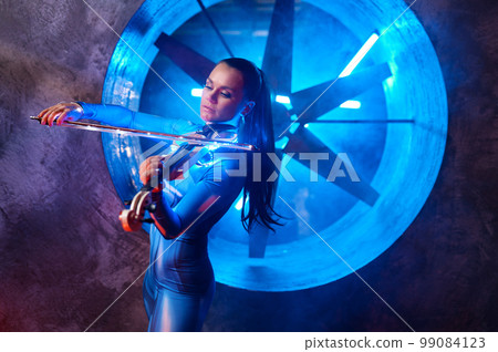 Artistic woman performer playing violin in atmospheric studio Artistic woman performer playing violin in atmospheric studio 99084123