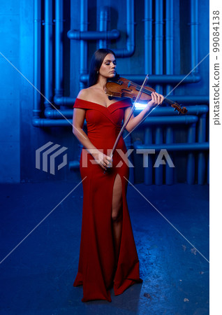 Young pretty woman playing violin solo over loft interior background Young pretty woman playing violin solo over loft interior background 99084138