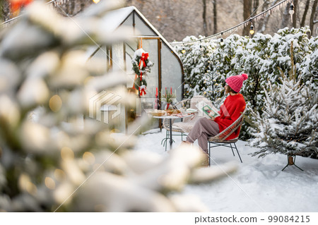 Woman at snowy backyard on winter holidays 99084215