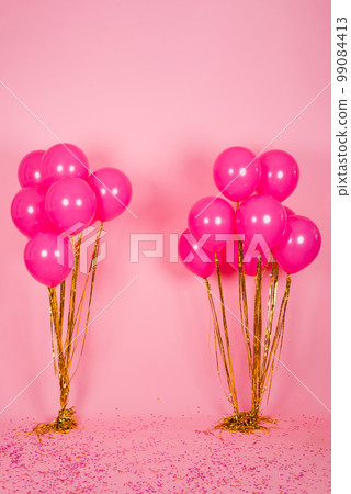 Festive fuchsia or pink balloons with gold threads, collected in a bouquet for a birthday, Valentine's Day or mom's Day 99084413