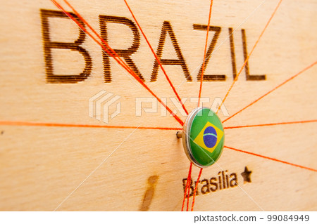 Brazil flag pins and red thread for traveling and planning trips. Planning of logistics routes or spheres of influence in geopolitics 99084949
