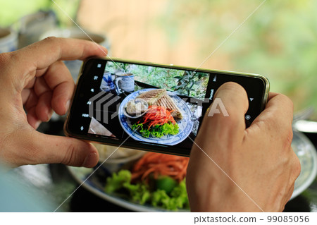 Taking pictures of food with a smartphone for social media post 99085056