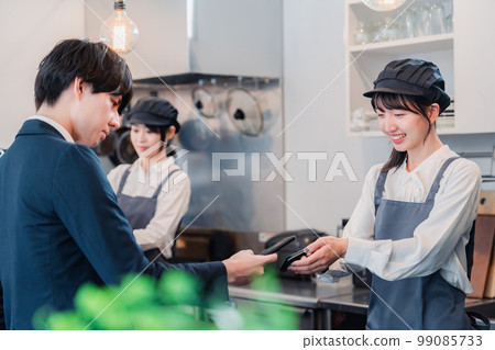 A man who makes a touch payment with a smartphone A man who makes a touch payment with a smartphone 99085733