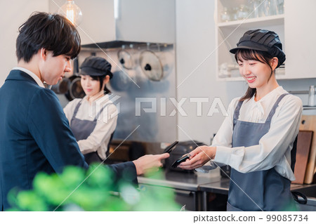 A man who makes a touch payment with a smartphone A man who makes a touch payment with a smartphone 99085734