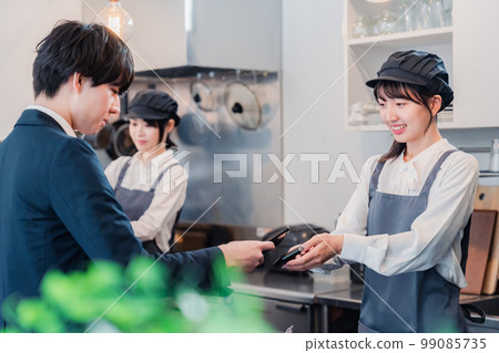 A man who makes a touch payment with a smartphone A man who makes a touch payment with a smartphone 99085735