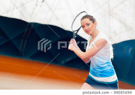 Attractive woman tennis player waiting for service at indoor court 99085899