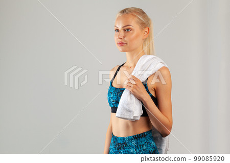 Beautiful young sports woman posing with towel on neck Beautiful young sports woman posing with towel on neck 99085920
