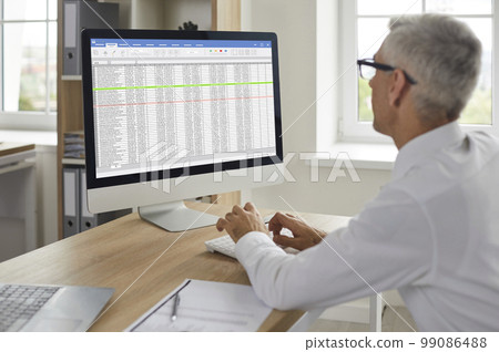Financial accountant working in the office and using business spreadsheets on the computer Financial accountant working in the office and using business spreadsheets on the computer 99086488