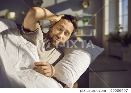 Attractive bearded young man just woke up and did not have time to open his eyes. 99086497