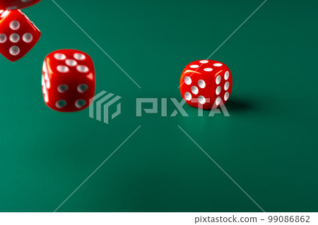 Red dice on green background close up 99086862
