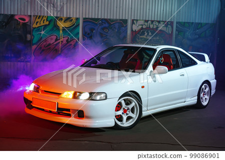90s sport car with smoke in neon light on the asphalt road at night 90s sport car with smoke in neon light on the asphalt road at night 99086901
