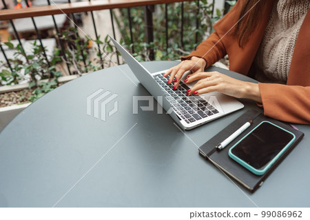 Cropped shot of a woman at cafe working on her laptop computer 99086962
