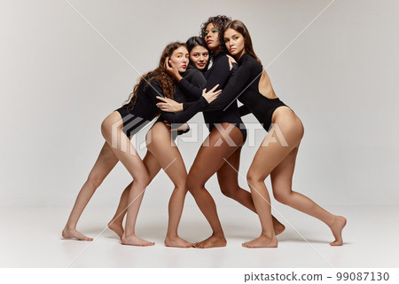 Multi ethnic young girls in black bodysuits posing together to show women beauty, power and unity. 99087130
